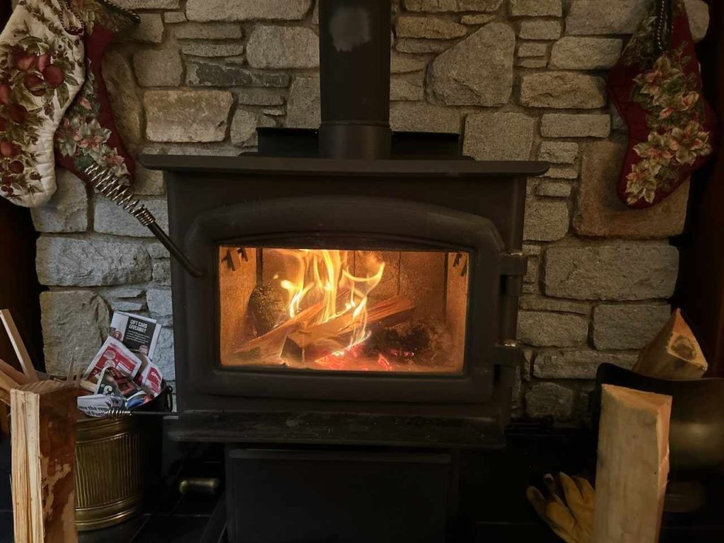 Comox Valley wood stove burns in front of a mantle