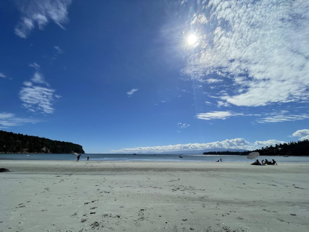 A sandy beach and beautiful blue water in the summertime.