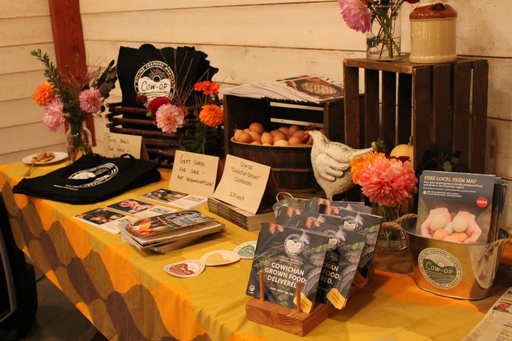 A table decorated with Cow-op merchandise, pamphlets, local cookbooks and more.