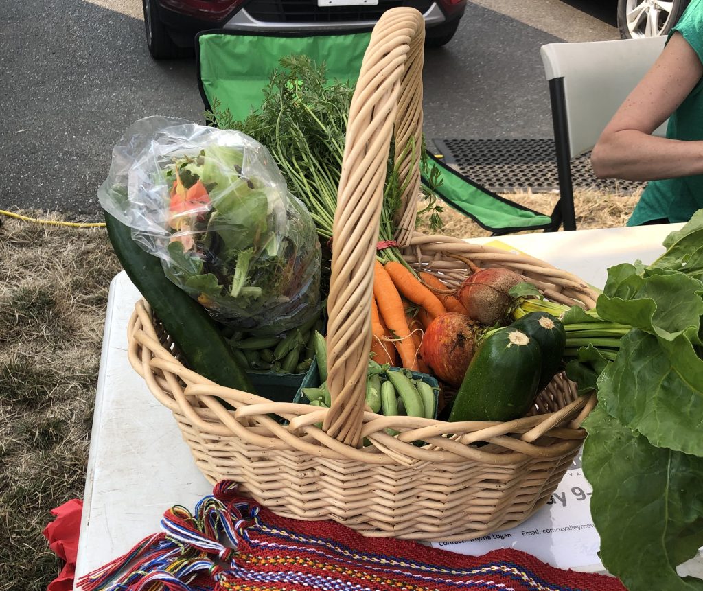 A basket full of vegetables on a table at Comox Valley Farmers' Market