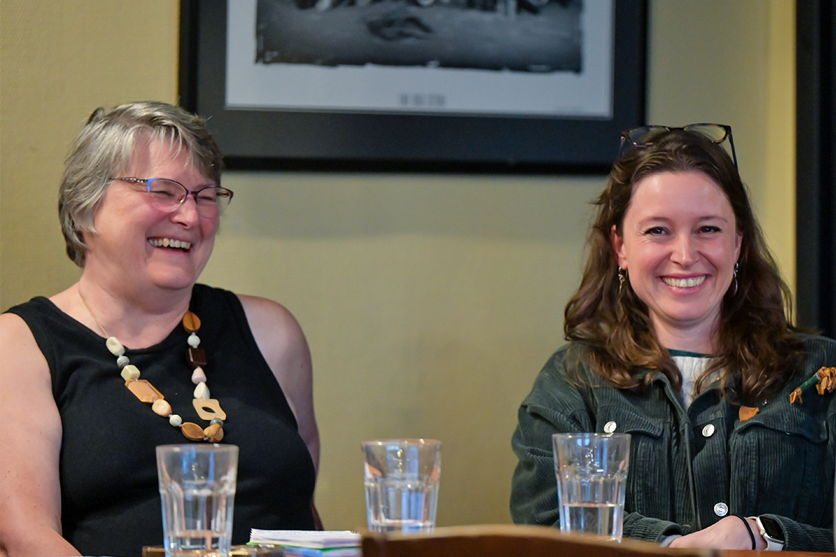 A photo of Bev and Laura laughing, sitting at a table. They were both panellists at the Discourse's event on women's health in the Cowichan Valley.