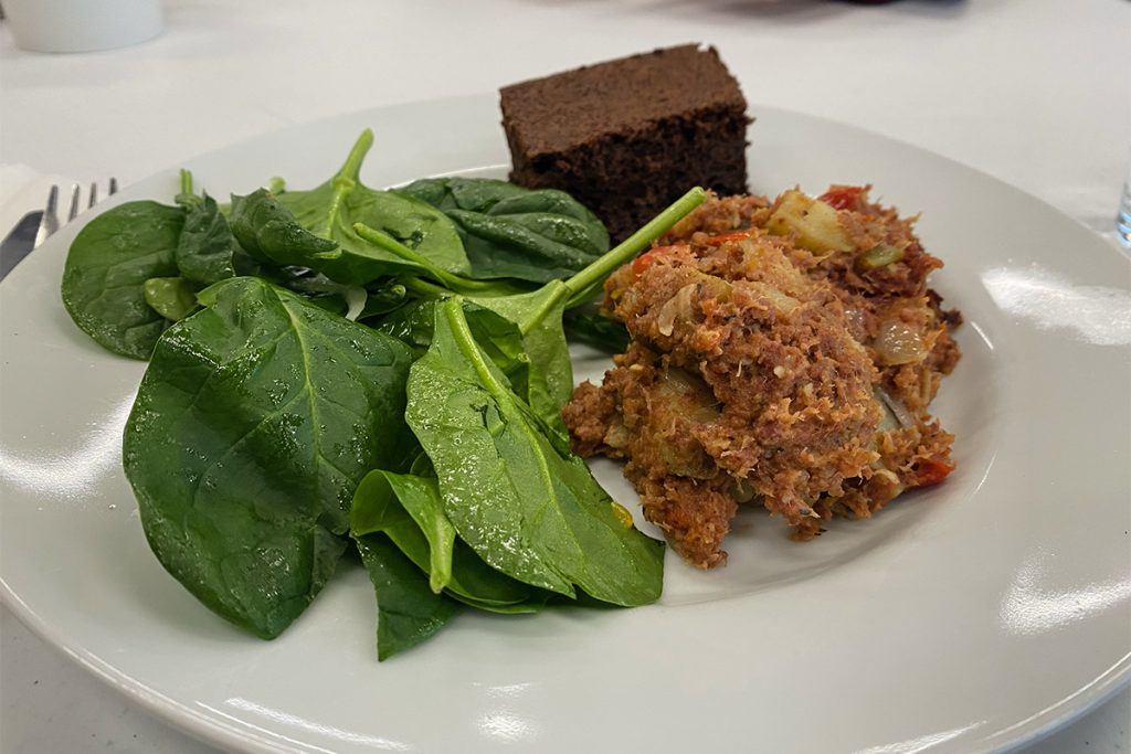 Photo of a plate with corned beef and hash with a spinach salad and an Irish cream brownie