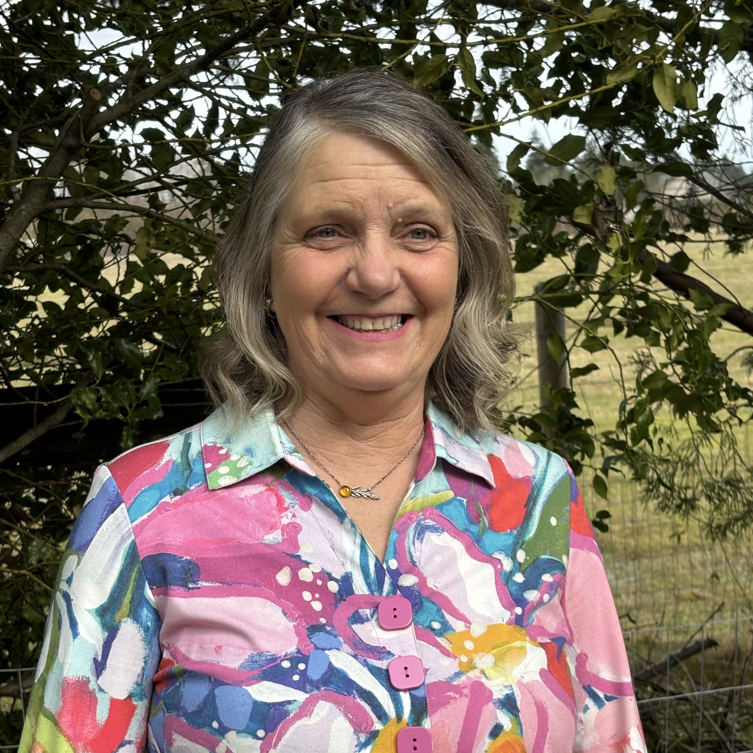 A woman standing in front of a tree.