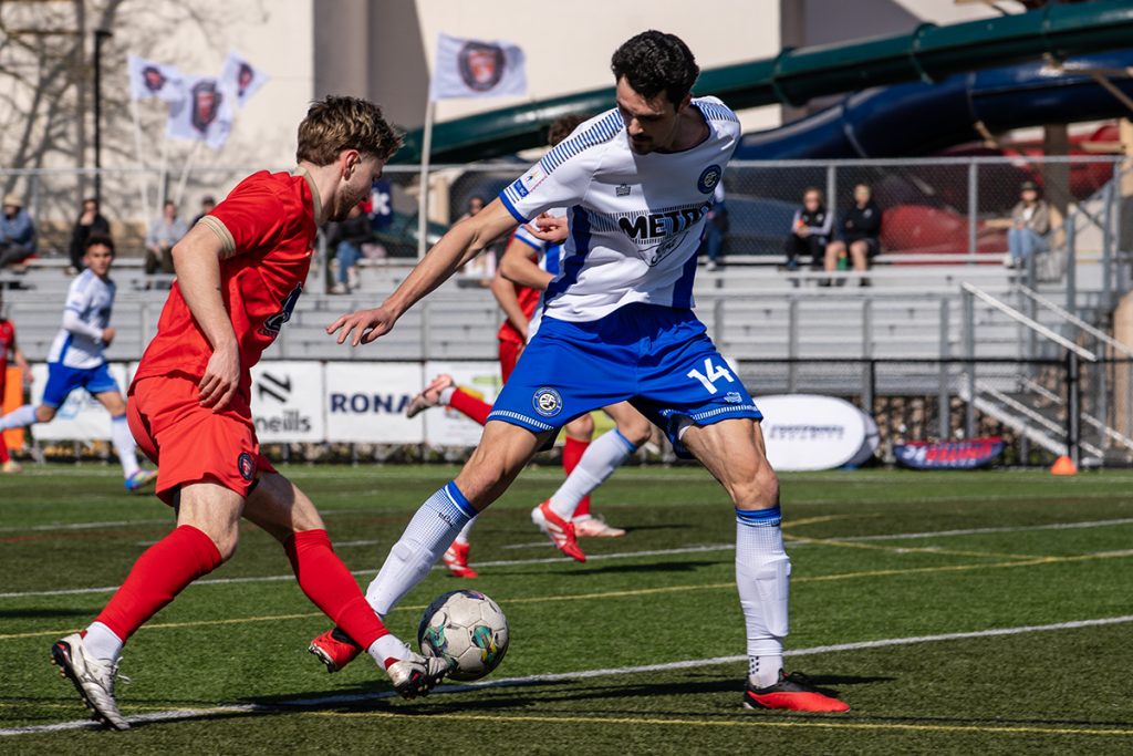 Namaimo United FC's Ashton Bryant is fouled by an Evolution FC player on April 12, 2025.