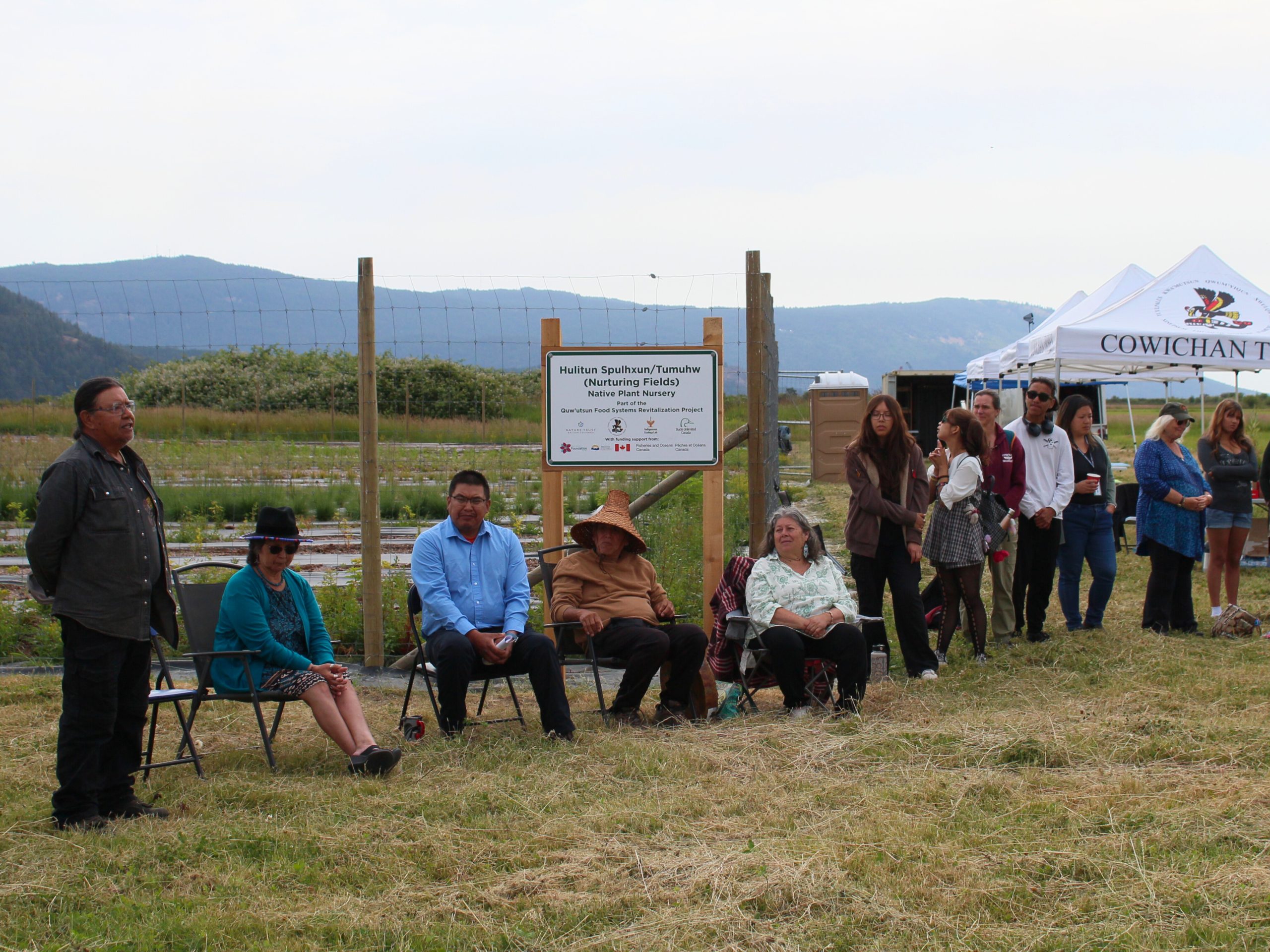 Siil'na'mut address the workshop in front of the Indigenous plant nursery. 