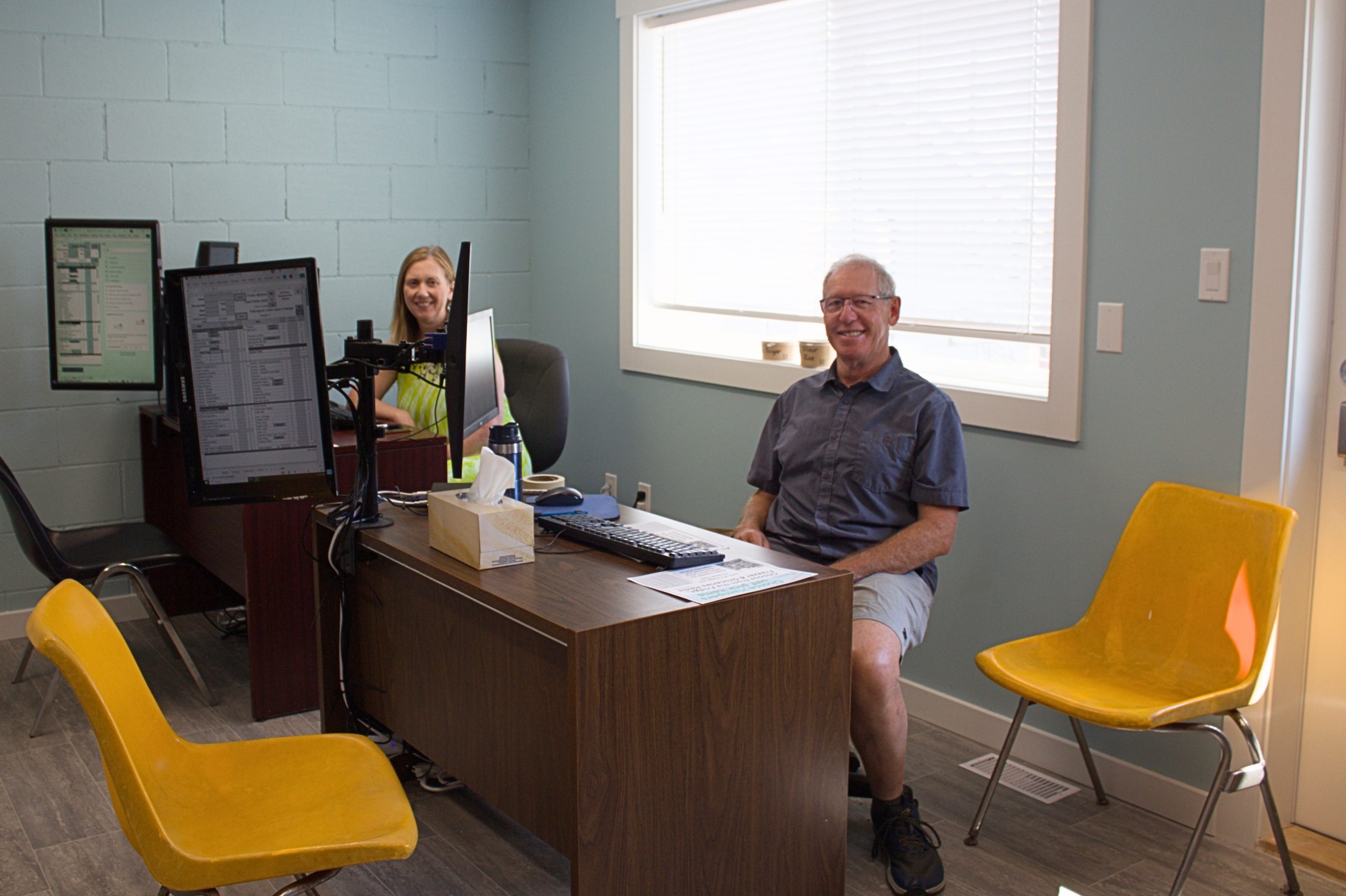 Greg Candy (right) and Heidi Paul (left) volunteer as hosts, helping clients build food hampers.