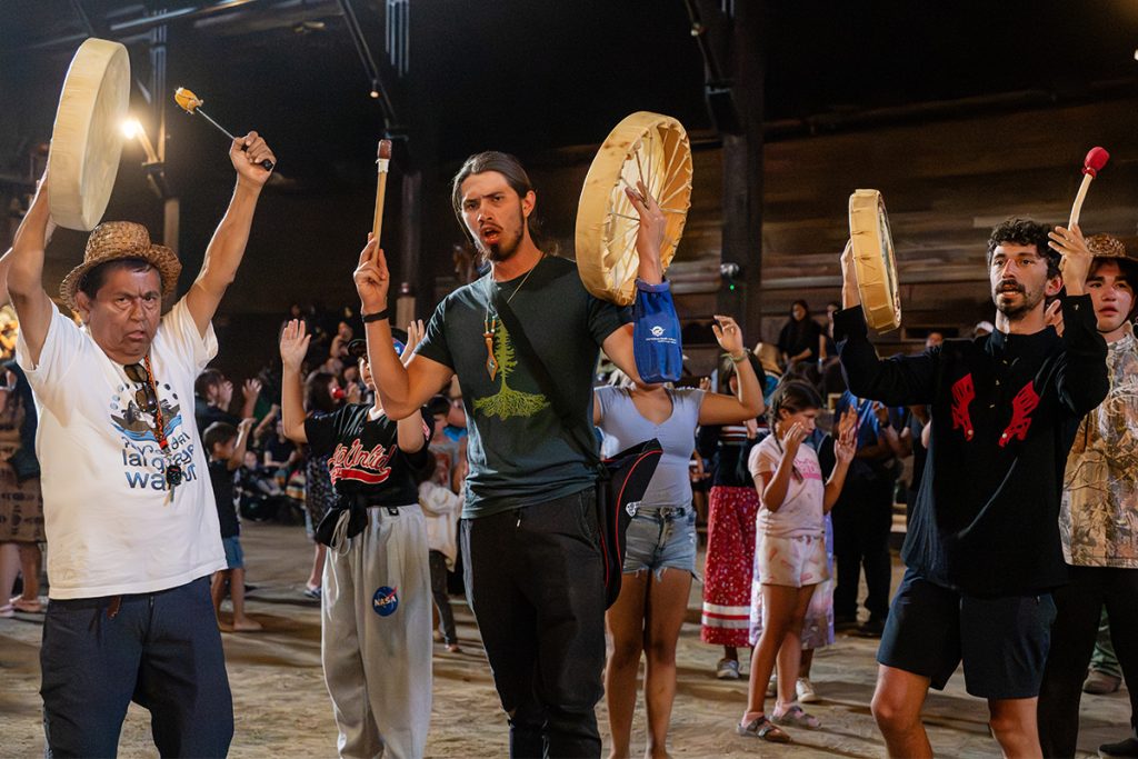 The Homalco, Klahoose and Tla'amin canoe families sing in the longhouse at Snuneymuxw Days 2025 after travelling to the community as part of Tribal Journeys. 