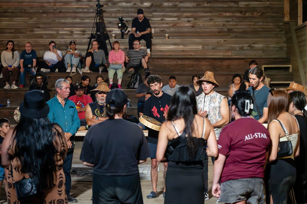 People drum and sing in the longhouse at Snuneymuxw Days 2025.