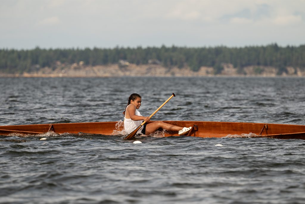 A girl's canoe tips during a race at  Snuneymuxw Days 2025.