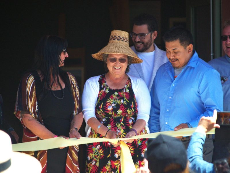 A group of people stands around a ribbon at the celebration opening the Shawnigan Lake Museum.