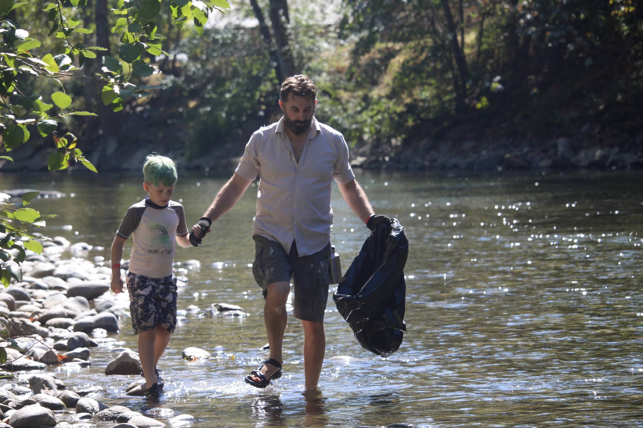 Two people walk along the river during the Cowichan River cleanup.