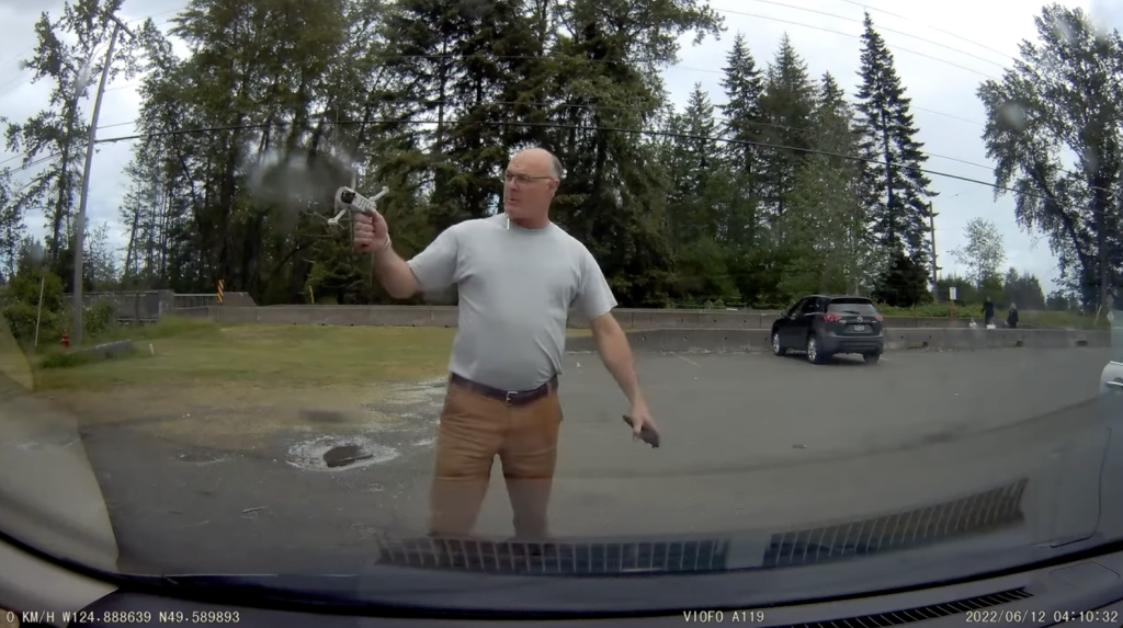 A screenshot of dashcam video of a man grabbing a drone as it lands. He is Deep Water Recovery's operations manager. The company has a shipbreaking operation in Union Bay