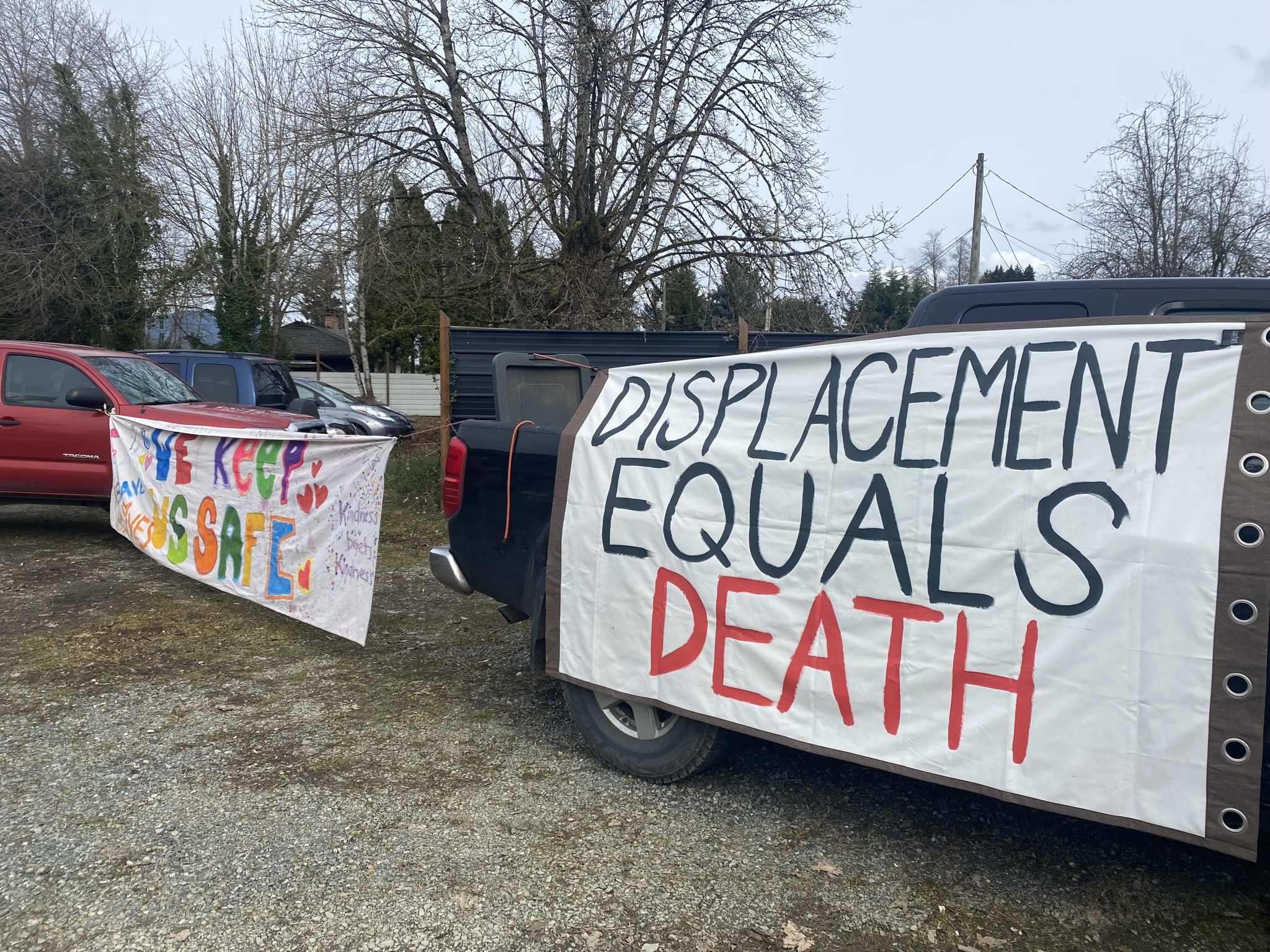 Two Banners at a rally held behind the temporary winter shelter in Duncan.