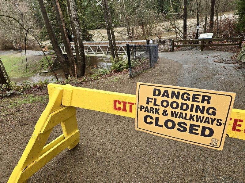 A danger sign and barricade blocks access to Puntledge Park. The sign reads Danger flooding closed
