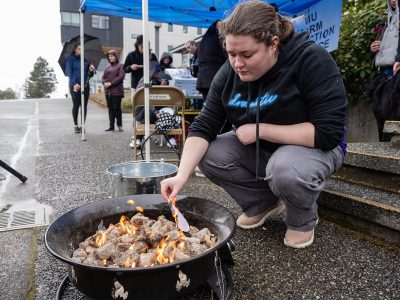 Hilary Nester, a social service worker student, burns a heart with a name of someone they were close to who died from the toxic drug crisis at a Grief Fire event at Vancouver Island University on April 14, 2026. Photo by Mick Sweetman / The Discourse.