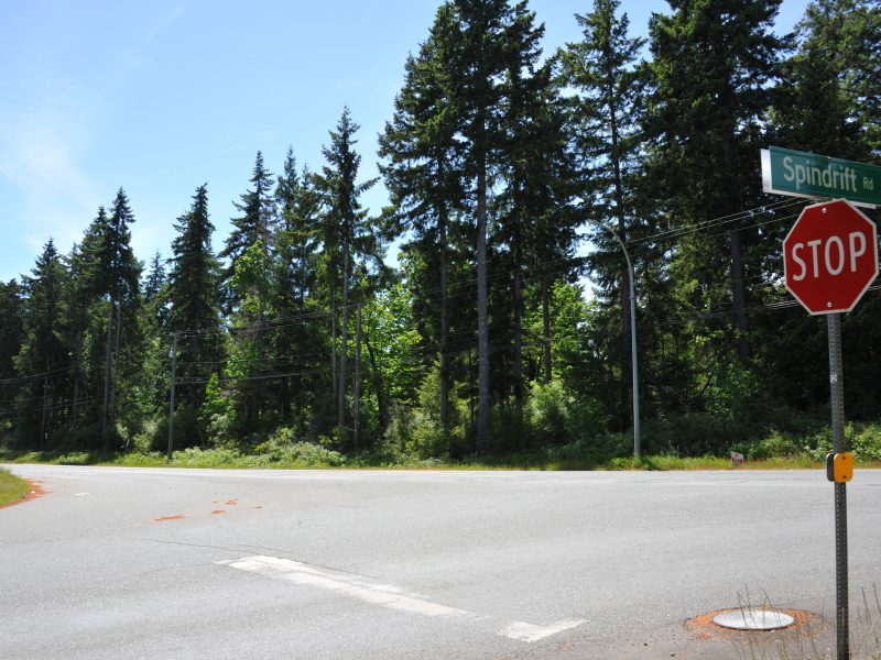 An image of a crossroad, with a stop sign on the far right, taken from K'ómoks First Nation territory that is included in the treaty.