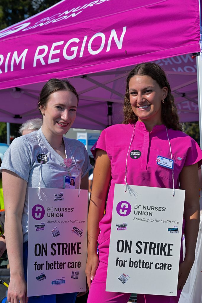 Two striking nurses stand on the picket line at the Nanaimo Regional General Hospital on July 13, 2026.