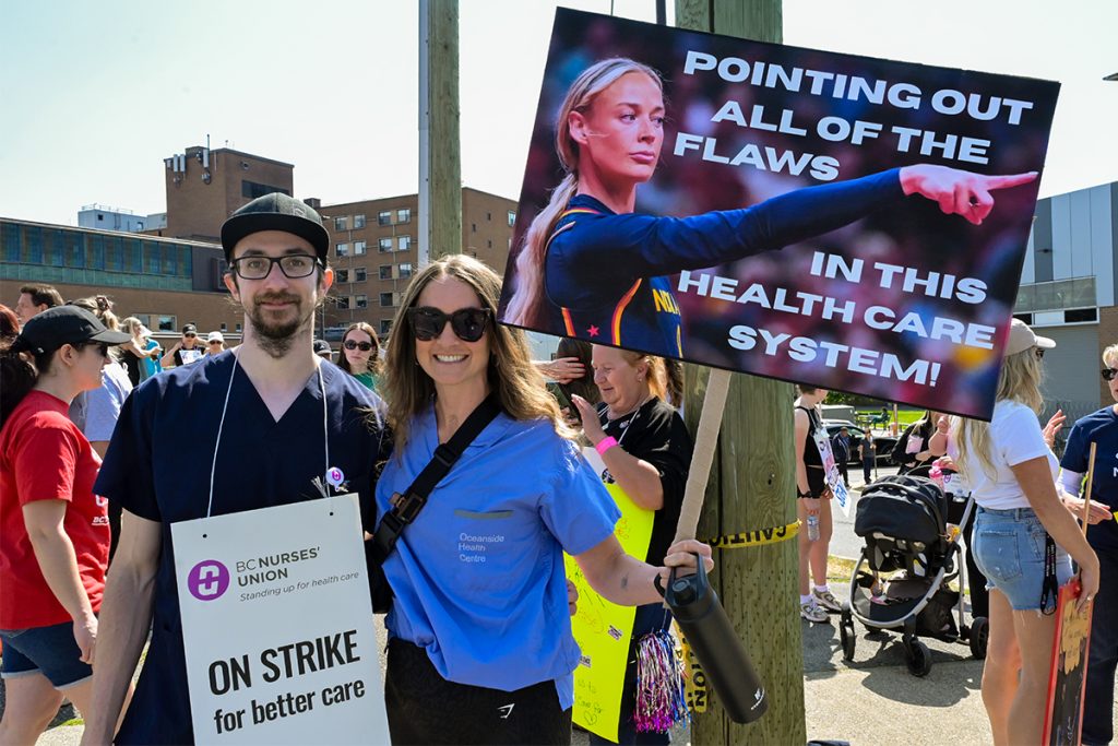 Striking nurses Darius Sawatsky and Kaitlyn Deas picket outside the Nanaimo General Hospital on Monday, July 13, 2026.