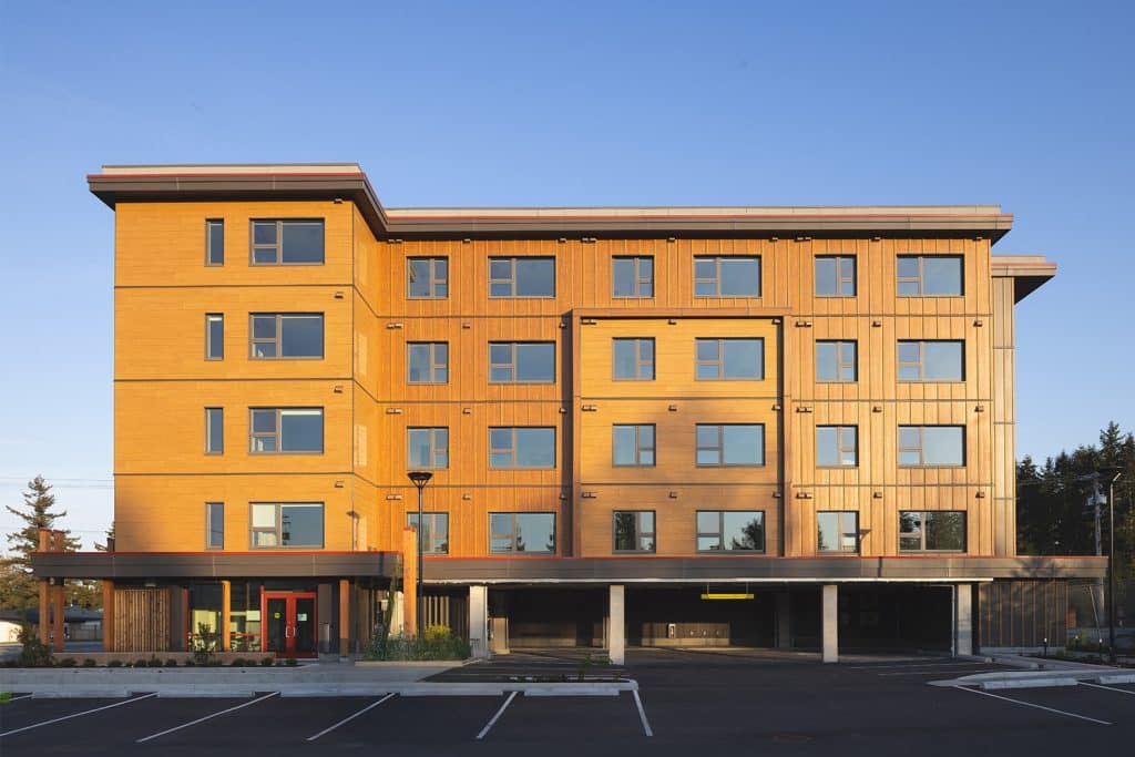 A bright housing complex is shown with blue sky in the background.