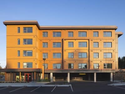 A bright housing complex is shown with blue sky in the background.