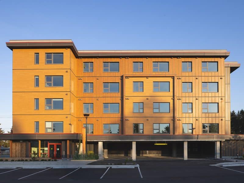 A bright housing complex is shown with blue sky in the background.